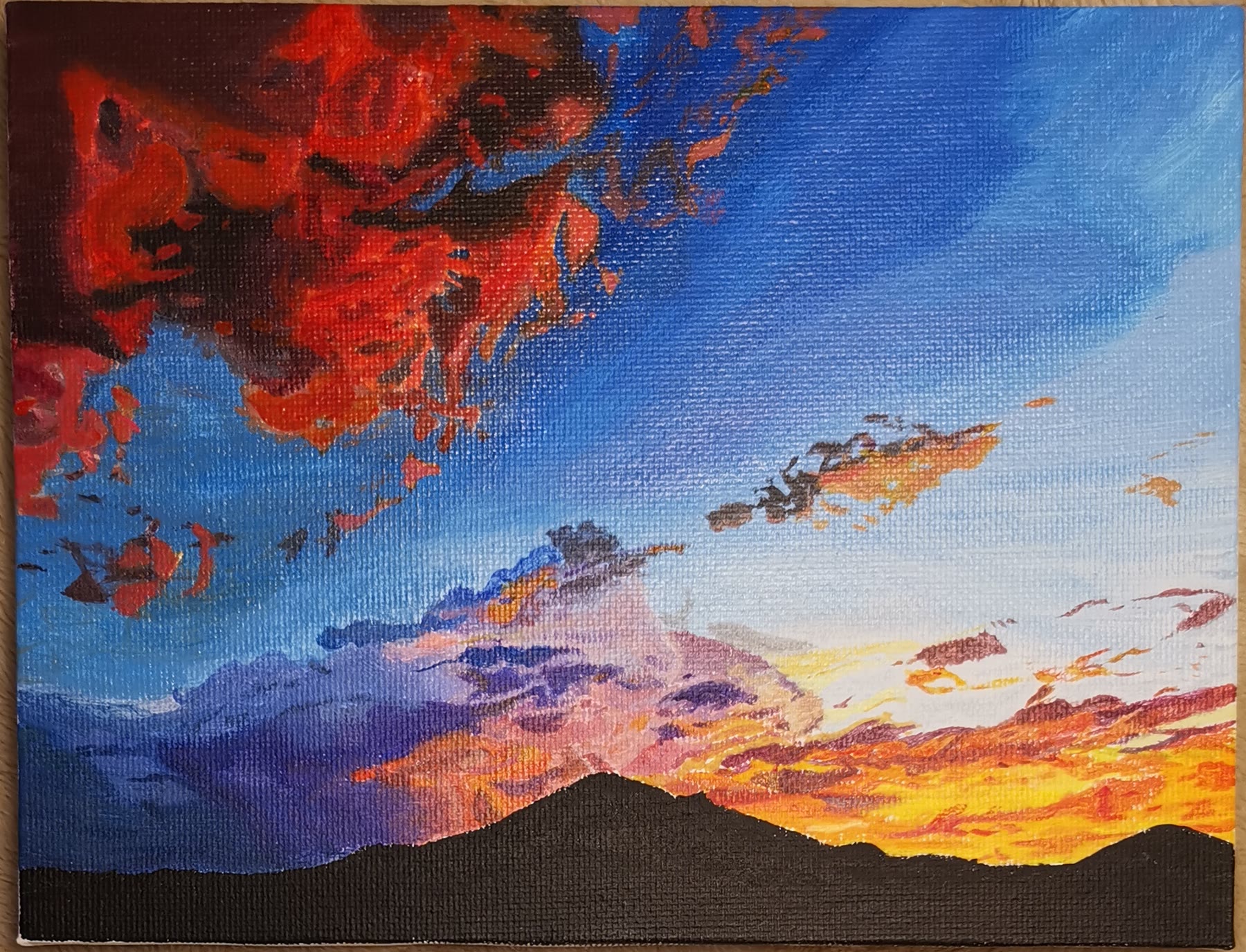Painting of a fiery sunset sky over a silhouetted mountain range